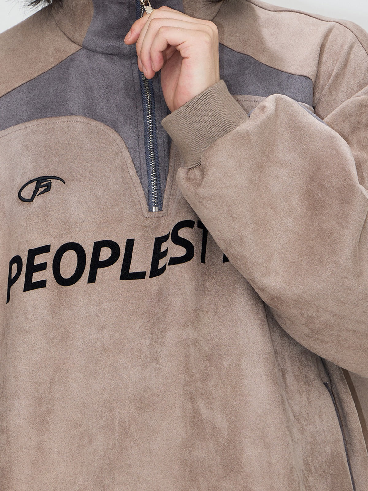 En daim touchent le pull à moitié zip